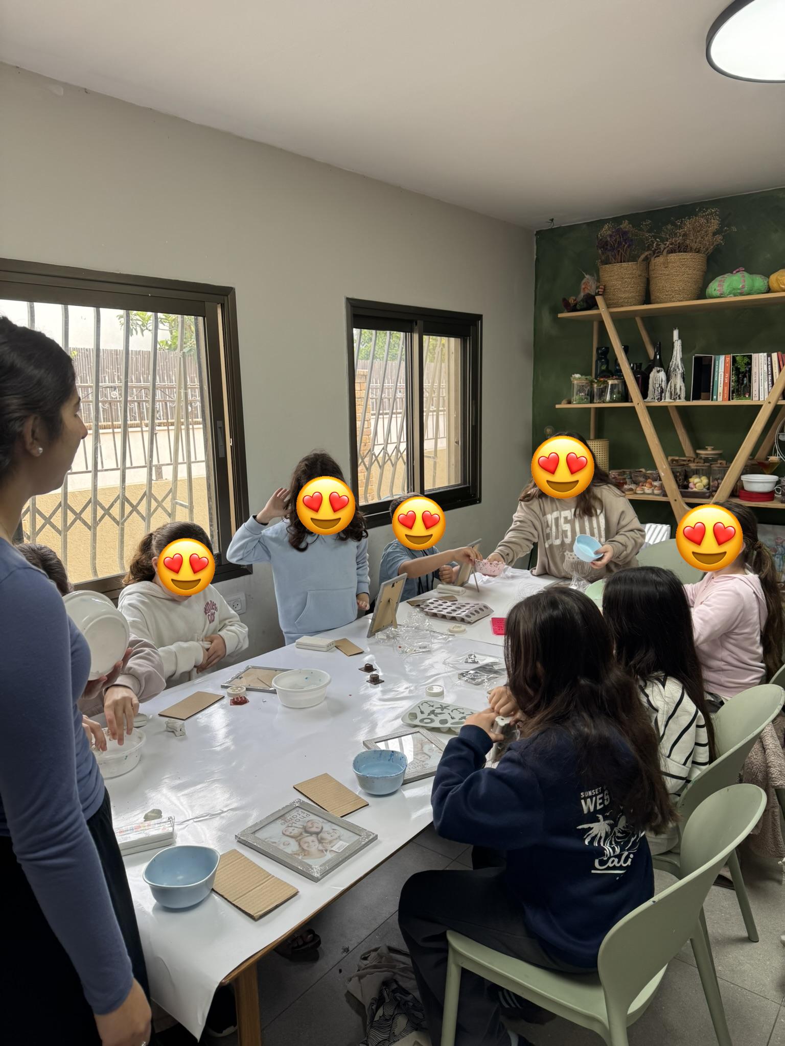 קבוצת ילדים בקייטנת יצירה — עובדים סביב שולחן בסטודיו